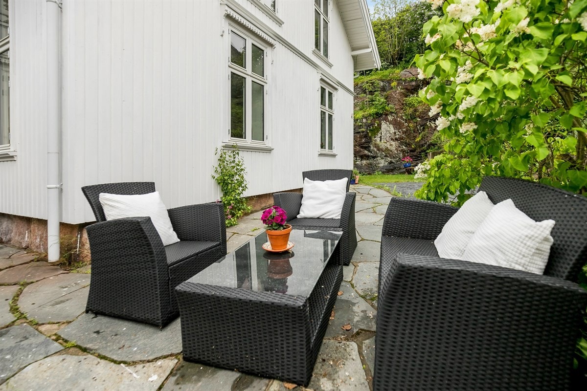 Skiferdekt uteplass omgitt av syriner. Galleribilde