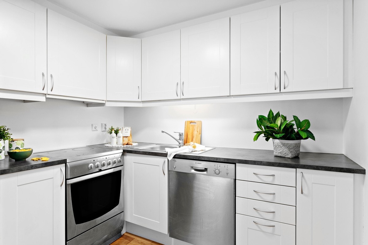 Pent kjøkken med hvite slette fronter. Galleribilde