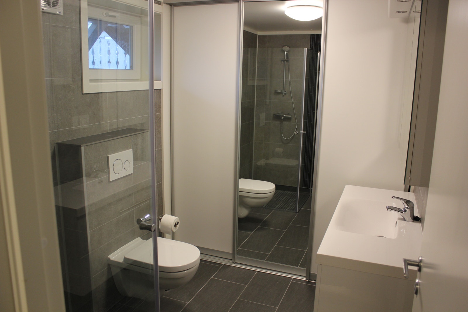 Bad med dusj og wc, vaskemaskin og tørketrommel Galleribilde