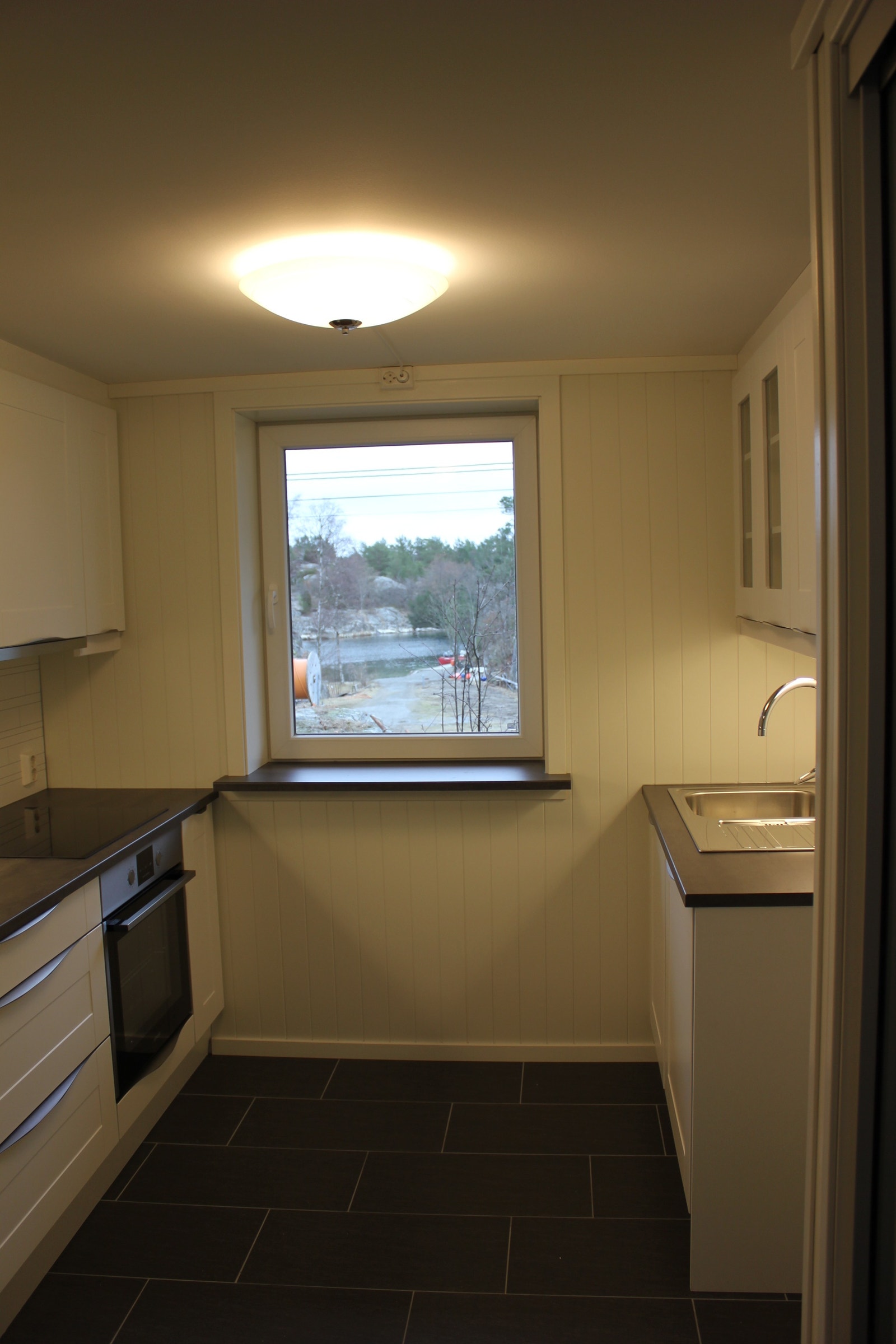 Kjøkken med oppvaskmaskin, kjøleskap og mikroovn. Utsikt til sjøen. Galleribilde