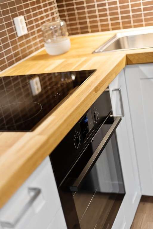 Veggmonterte stikkontakter over kjøkkenbenken gjør det praktisk å bruke elektrisk kjøkkenustyr. Eksempelbilde. Galleribilde