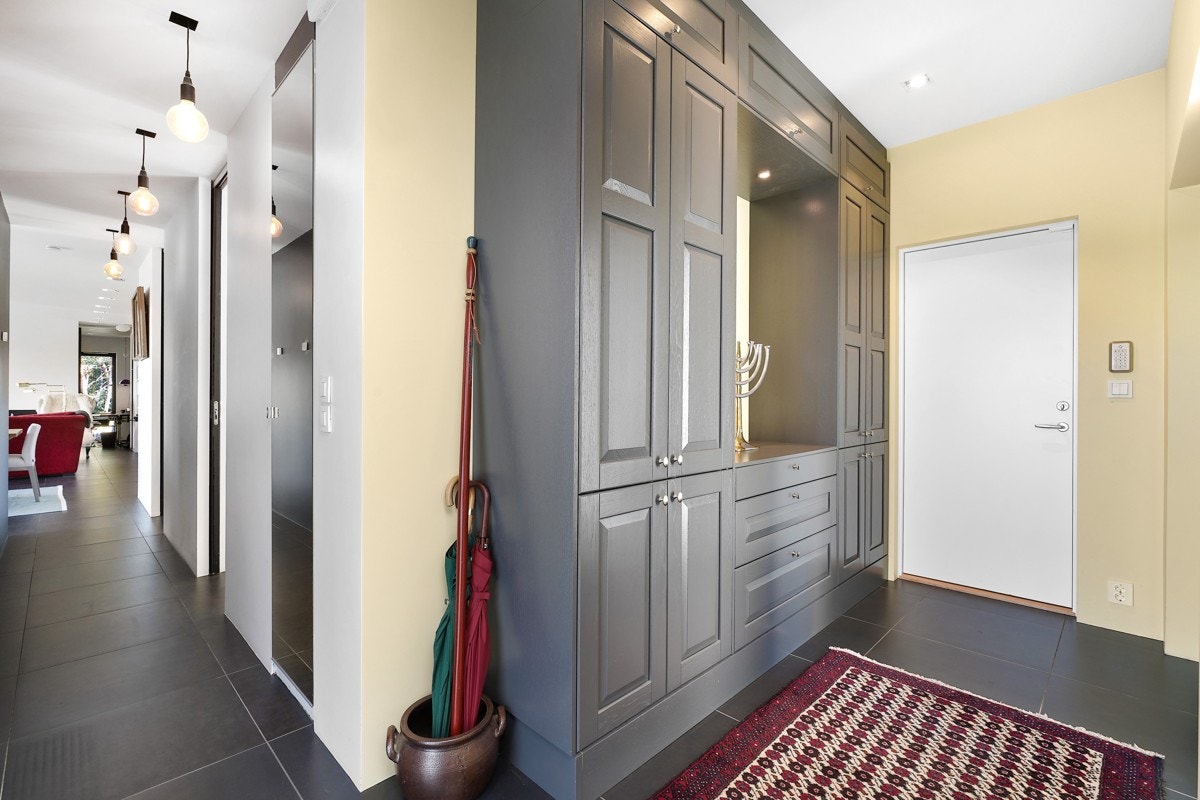 Rett innenfor hoveddøren er det et plassbygd skap med grå fronter og flere skuffer. Galleribilde