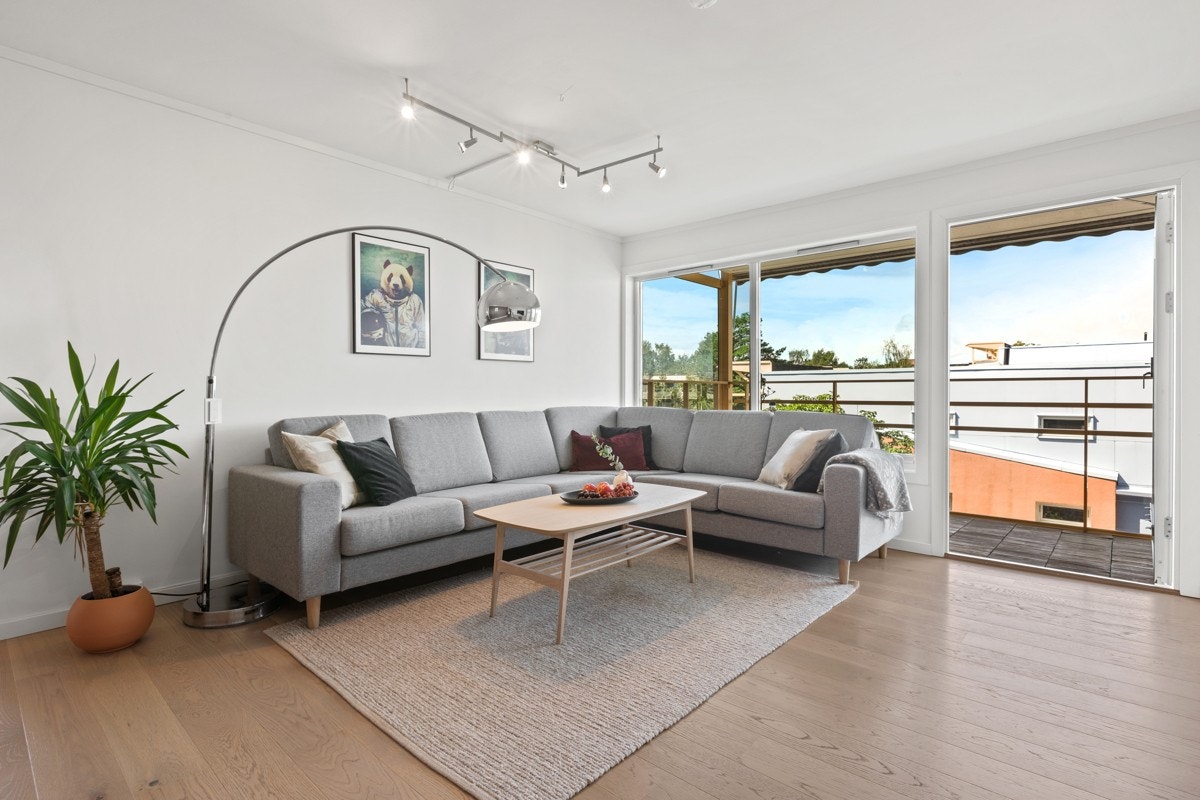 Stuen oppleves lys og luftig med gode vindusflater som slipper inn rikelig med dagslys Galleribilde