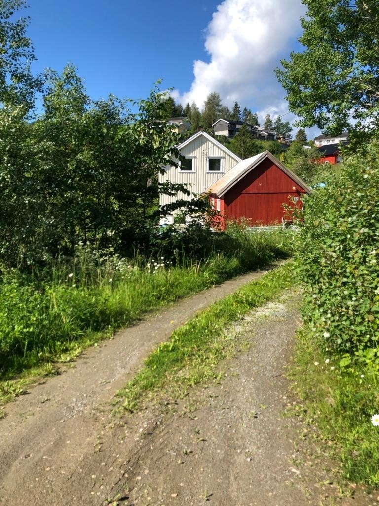 Innkjørsel til huset med stor utebod i front. Galleribilde