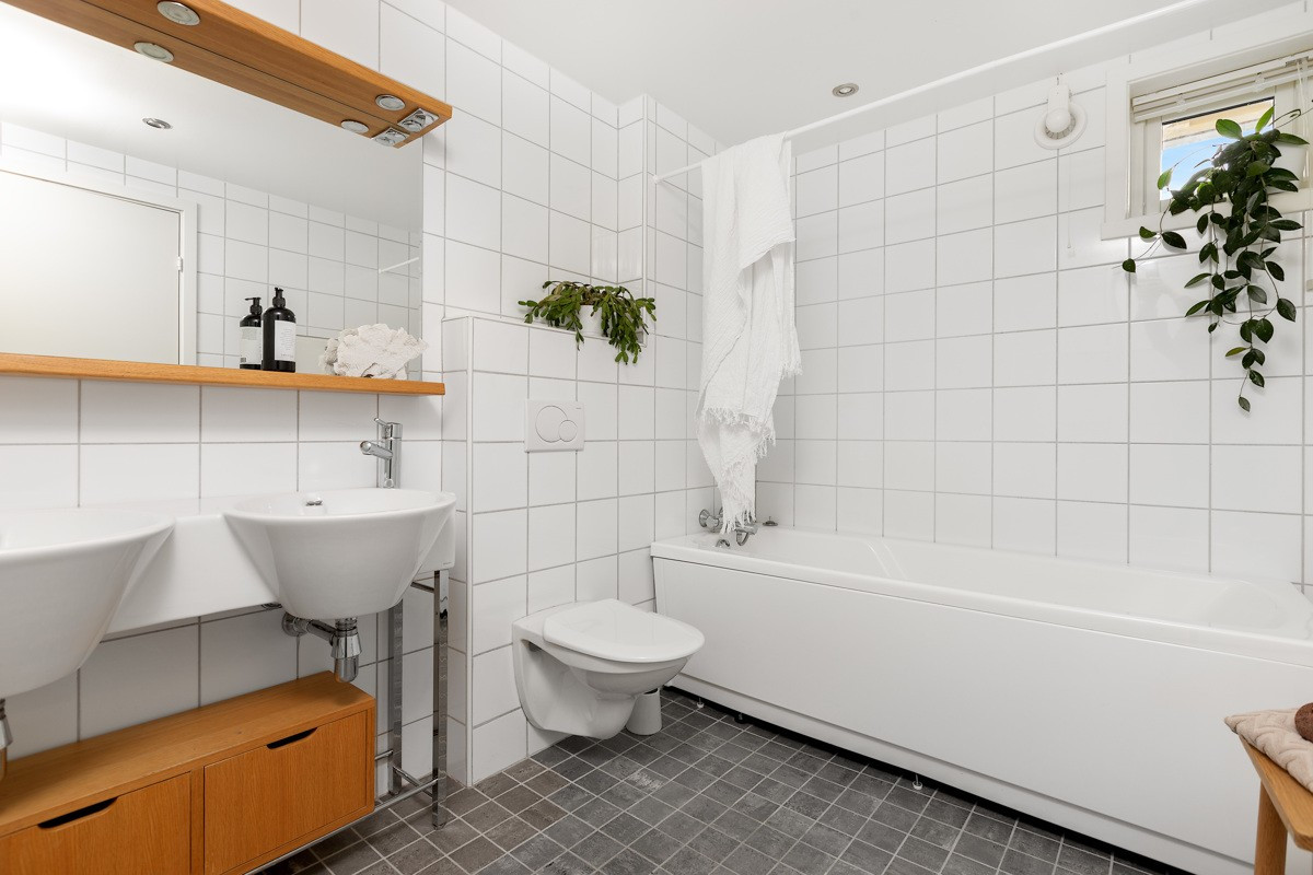Stort og flislagt bad i leilighetens nedre plan