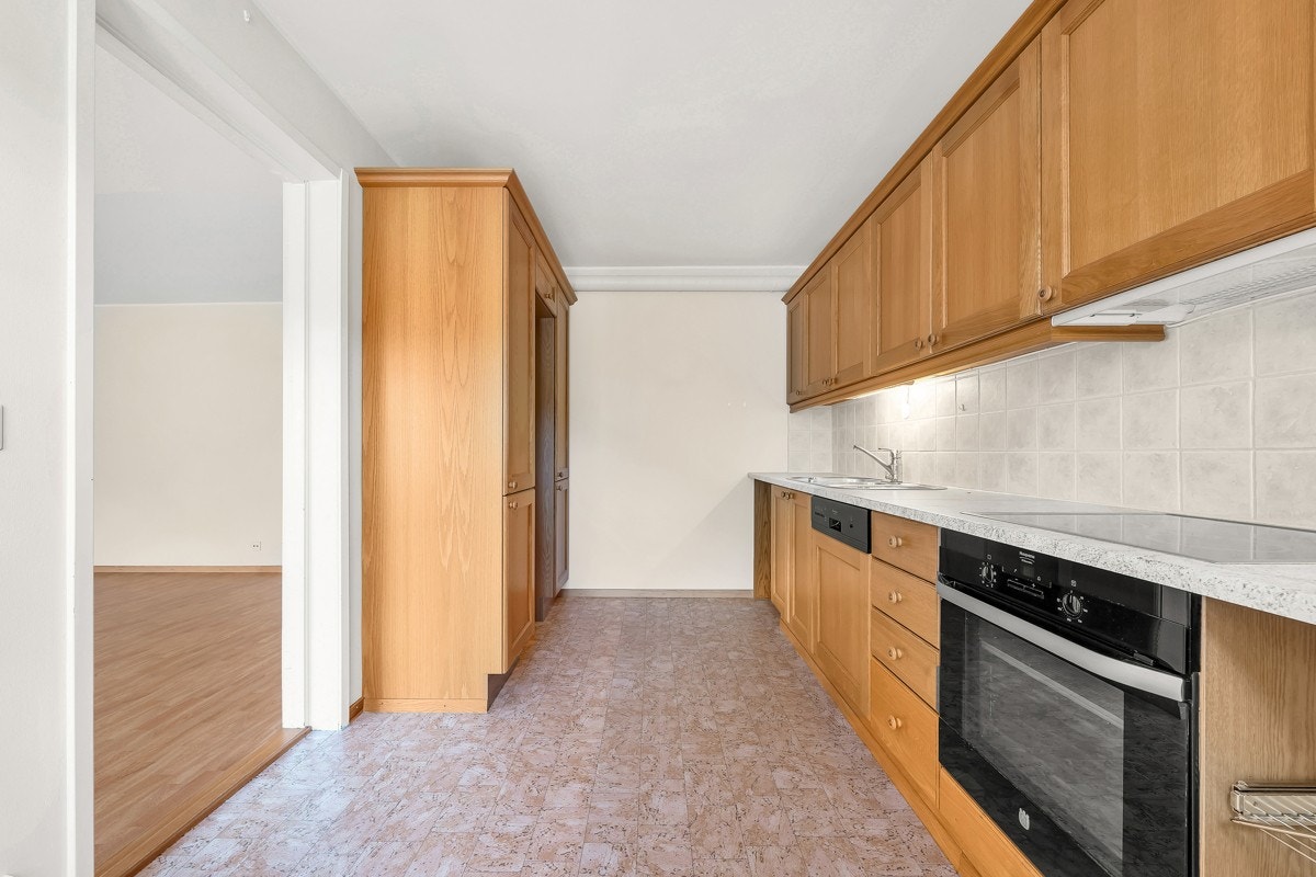 Innredning med profilerte fronter og fliser over benkeplate. Galleribilde