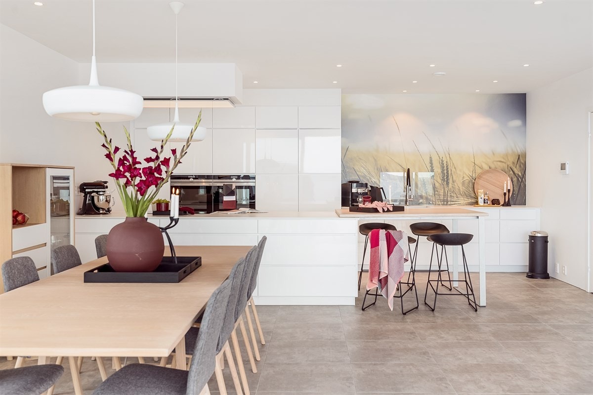 Dekton benkeplate med overliggende plate i hvitlasert bambus sørger for spisemuligheter ved kjøkkenøyen. Galleribilde