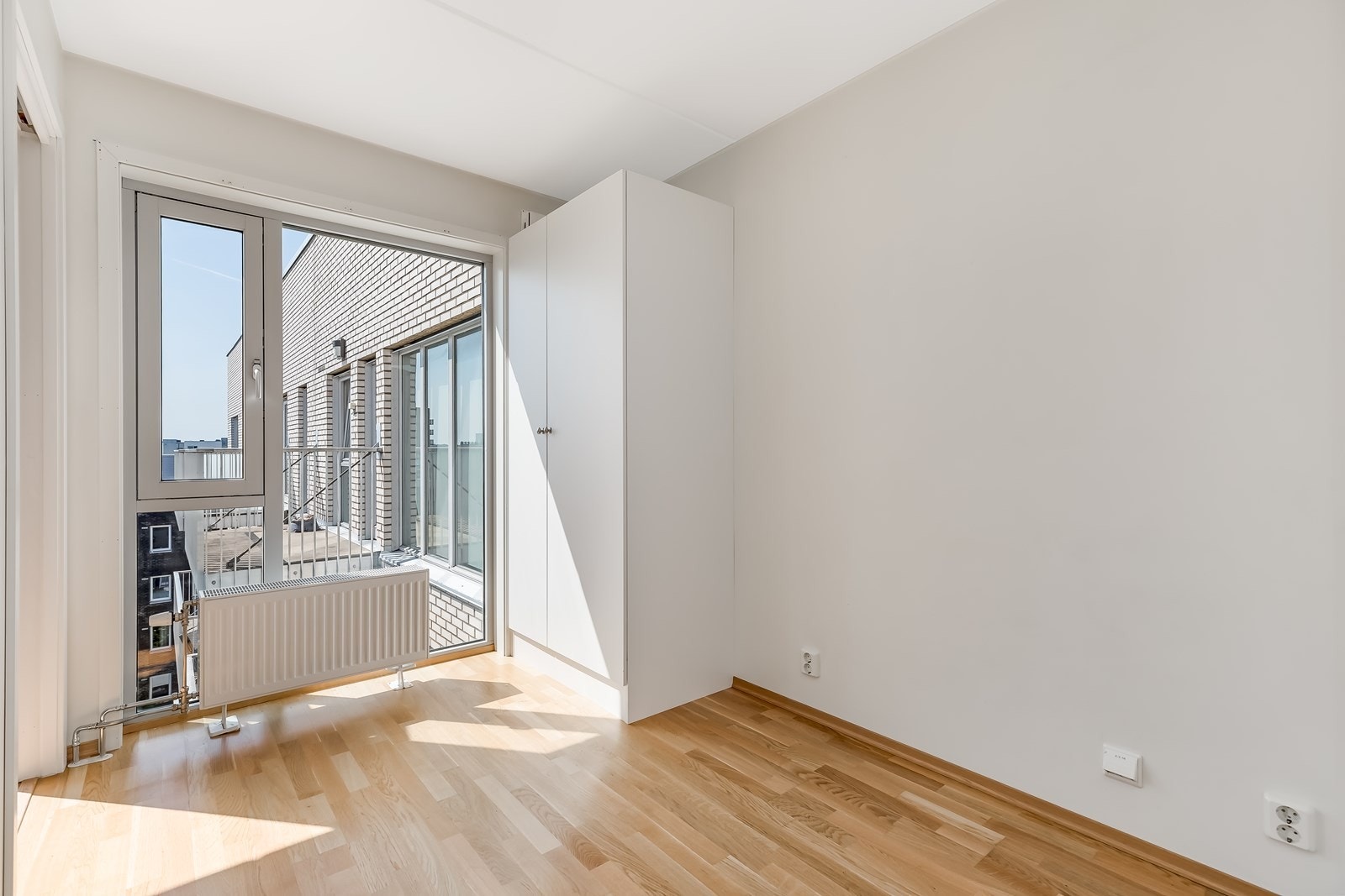 Soverom med parkett på gulvet og lyse farger på veggene. Galleribilde