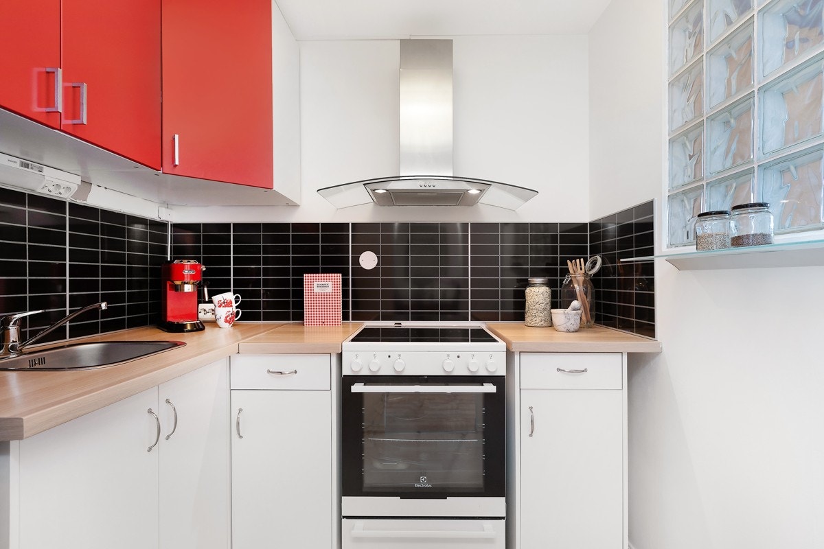 Kjøkkeninnredning med laminat benkeplater og glatte fronter med stålhåndtak. Galleribilde