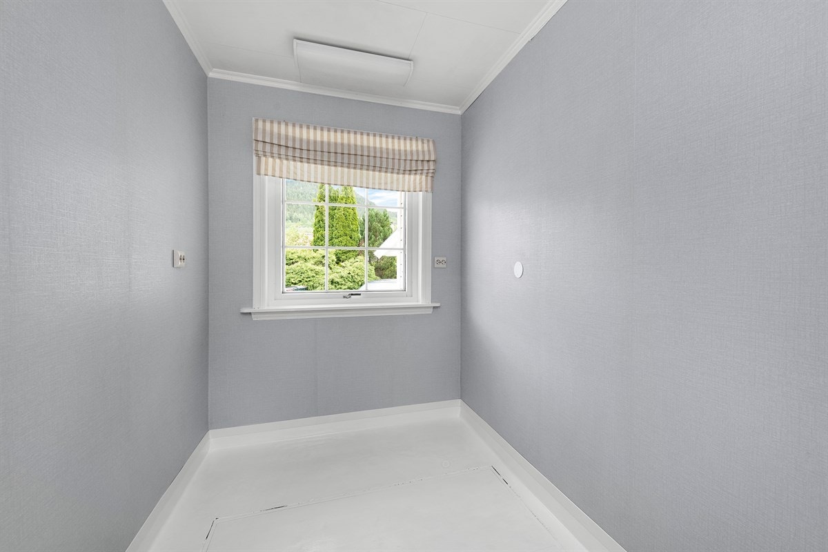 Rommet er innredet med vaskekum i stål, har en nyere varmtvannsbereder og opplegg for vaskemaskin. Det er en luke i gulv med trapp til kjelleetasjen på vaskerommet. Galleribilde