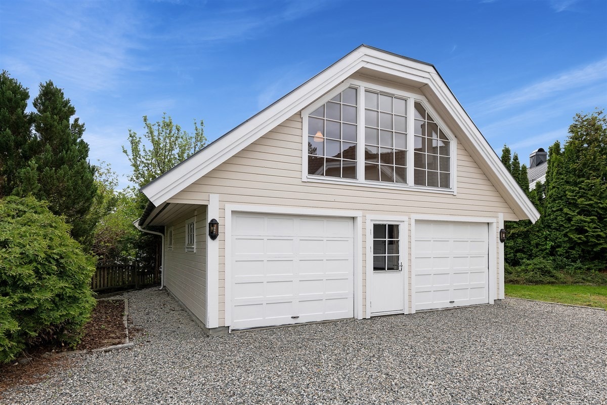 Tomten har en romslig, singlet gårdsplass mellom eneboligen og en dobbeltgarasje med innredet loft. Galleribilde