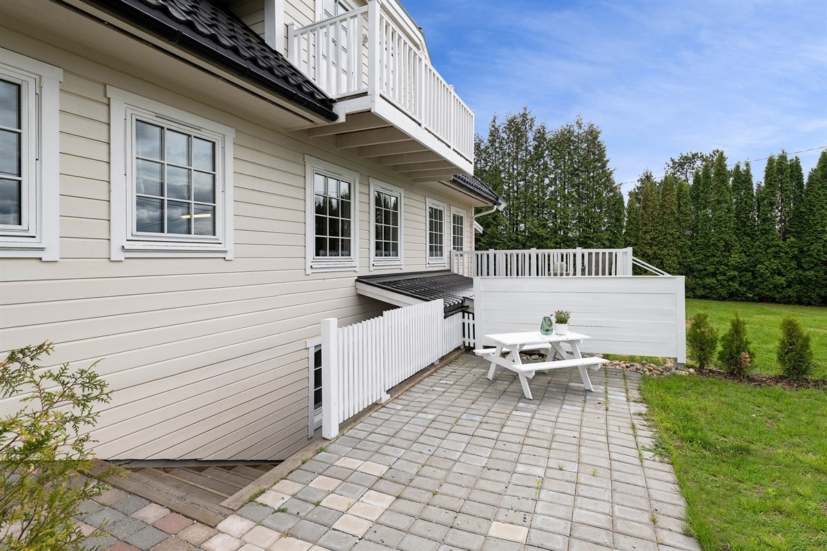 Midt i hagen er det plantet hekk og satt opp levegg til en egen, steinsatt uteplass foran kjellerinngangen. Dette gir en privat sone om man ønsker å ha leieboer. Galleribilde