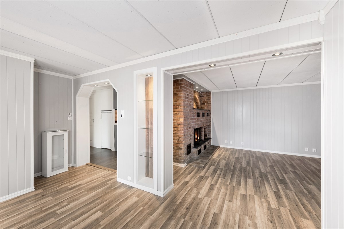 Stuen deles i to soner, og det er tilknyttet kjøkken med grå fliser på gulv og gulvvarme. Kjøkkeninnredningen er fra 2017. Galleribilde