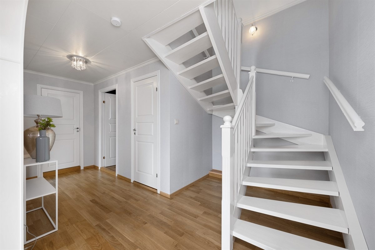 Fra entreen er det bueåpning til mellomgang, og videre til hall, som er dels åpen med stuen. Galleribilde