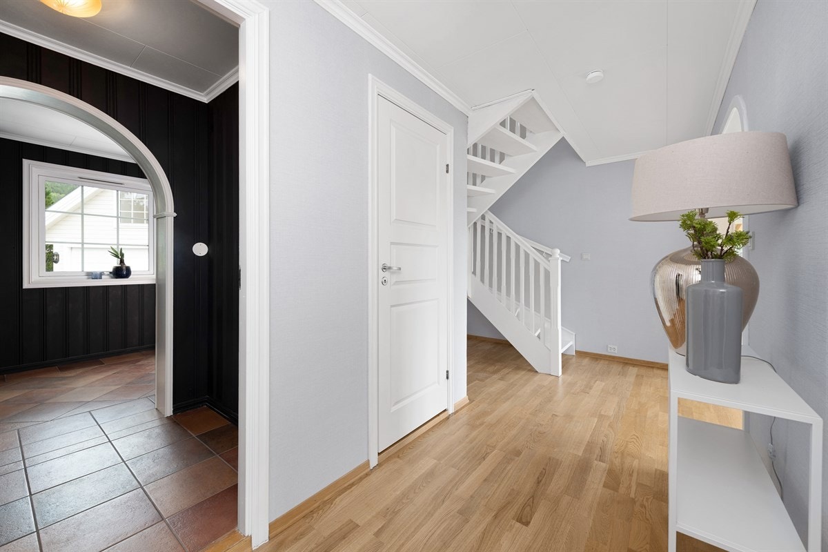 Fra entreen er det bueåpning til mellomgang, og videre til hall, som er dels åpen med stuen. Galleribilde