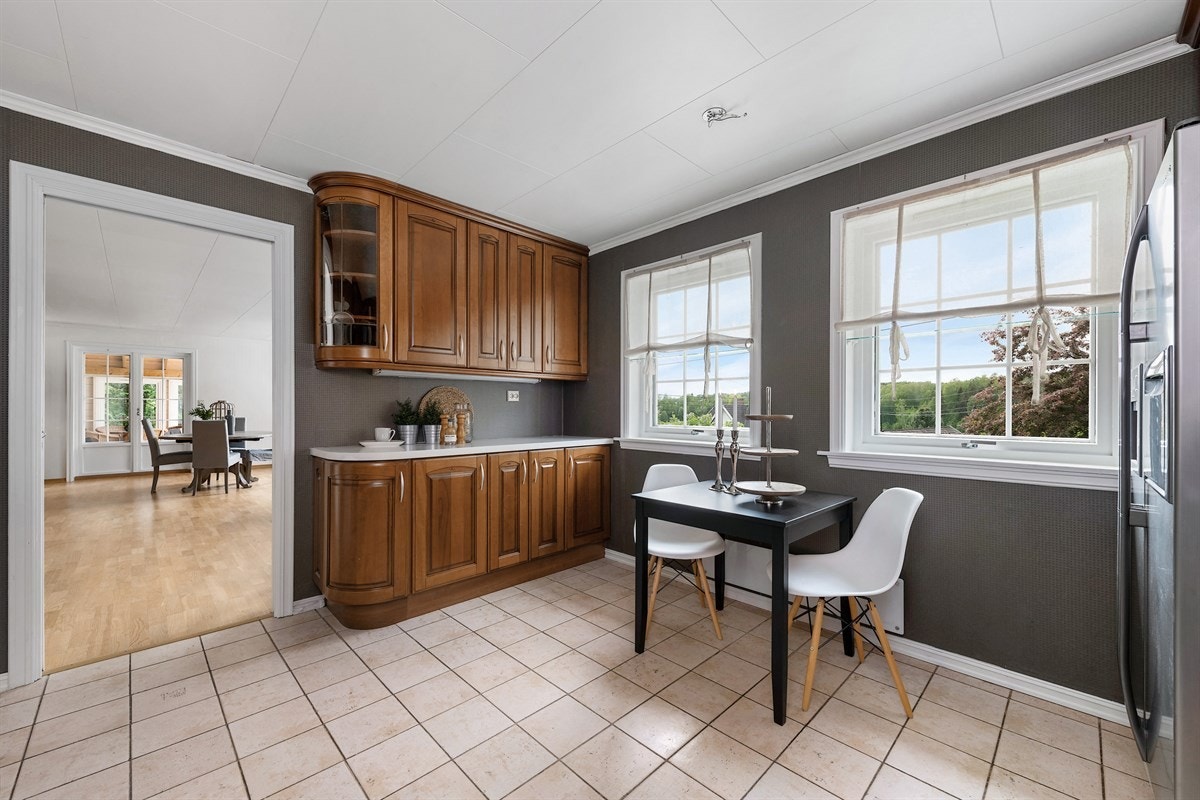 Rommet har to store sprossevinduer, tapet på vegger og gulv med fliser. Galleribilde