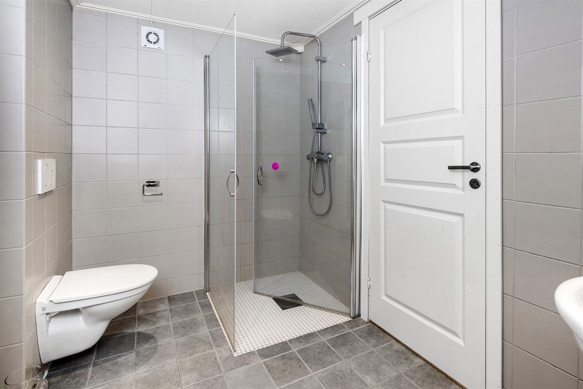 Badet ble bygd i 2017, er moderne, pent og praktisk. Det er grå steinfliser på gulv, glatte, grå fliser på veggene, varme i gulv og downlights i tak. Galleribilde