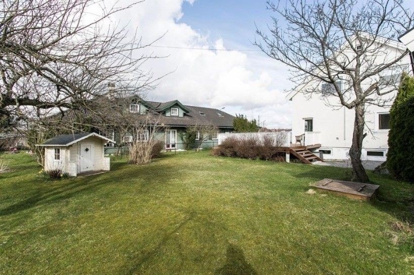 Stor hage og terrasse med rottingmøbler og gassgrill Galleribilde