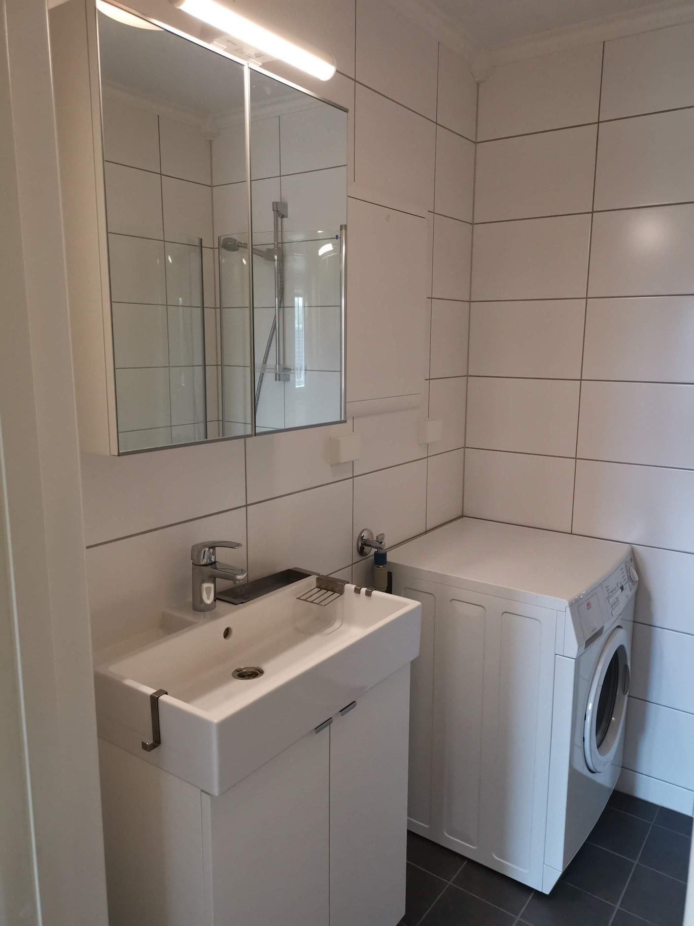 Fliselagt bad med varmekabler i gulv og vaskemaskin Galleribilde