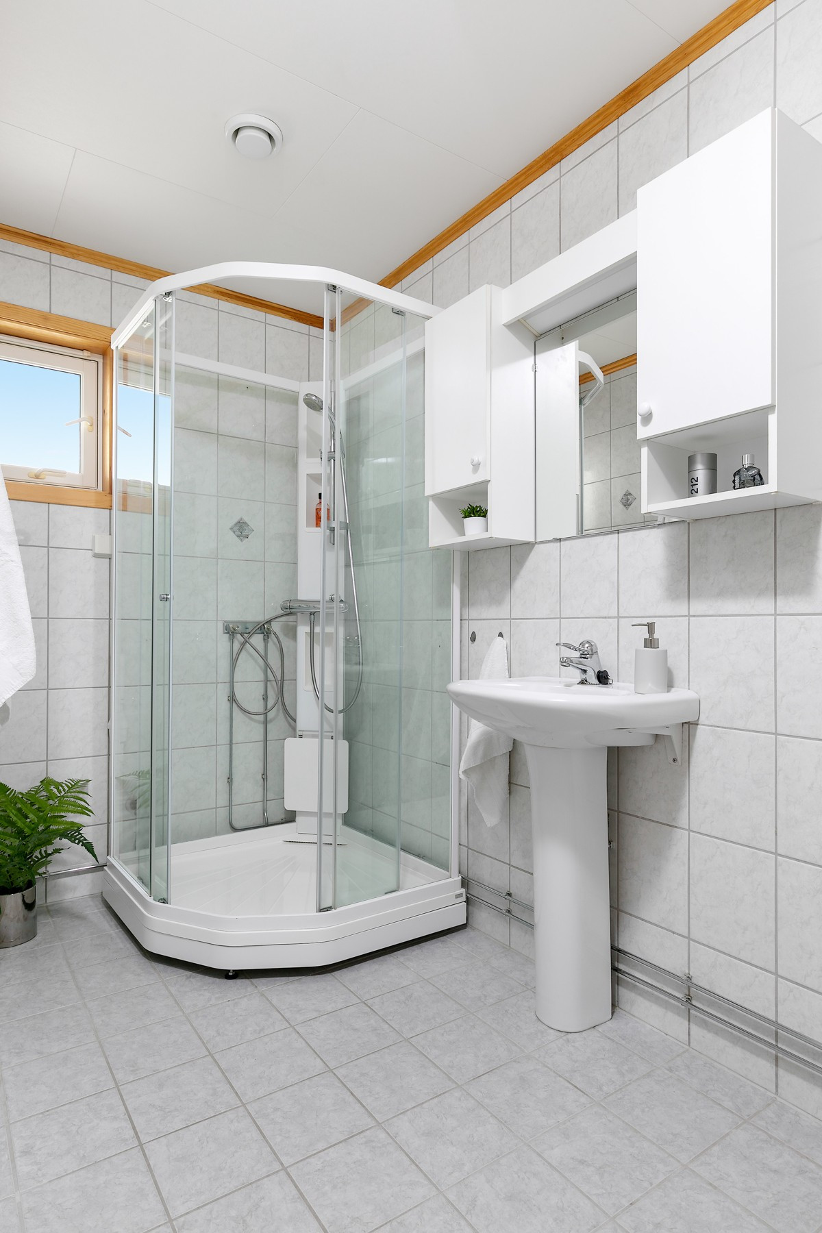 Bad i 1. etasje er komplett fliselagt med gulvvarme, og er innredet med wc, bidet, dusjkabinett og servant med speil
