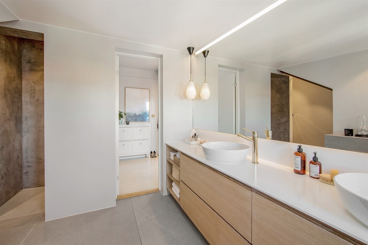 Plassbygget hylle i eik og messingfug mellom gulvflisene Galleribilde