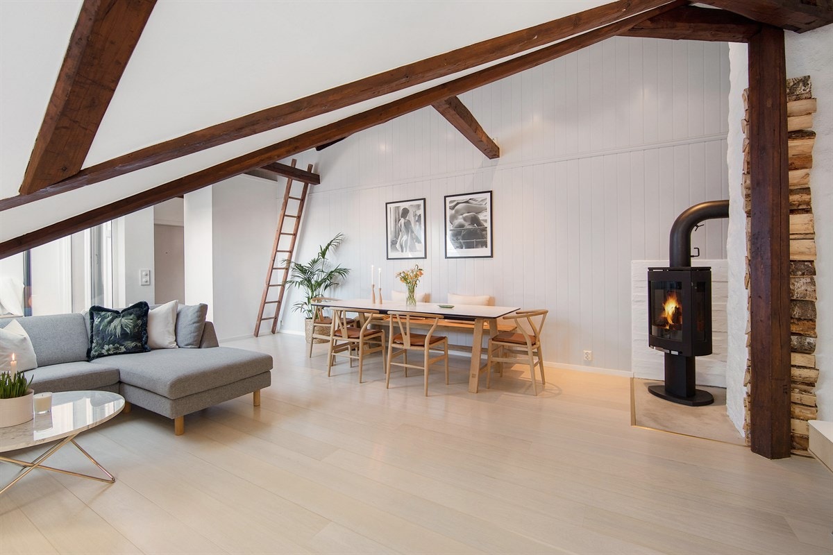 Stuens vinkelform gir ytterligere særpreg og det er hygge fra en moderne peisovn fra 2015 Galleribilde