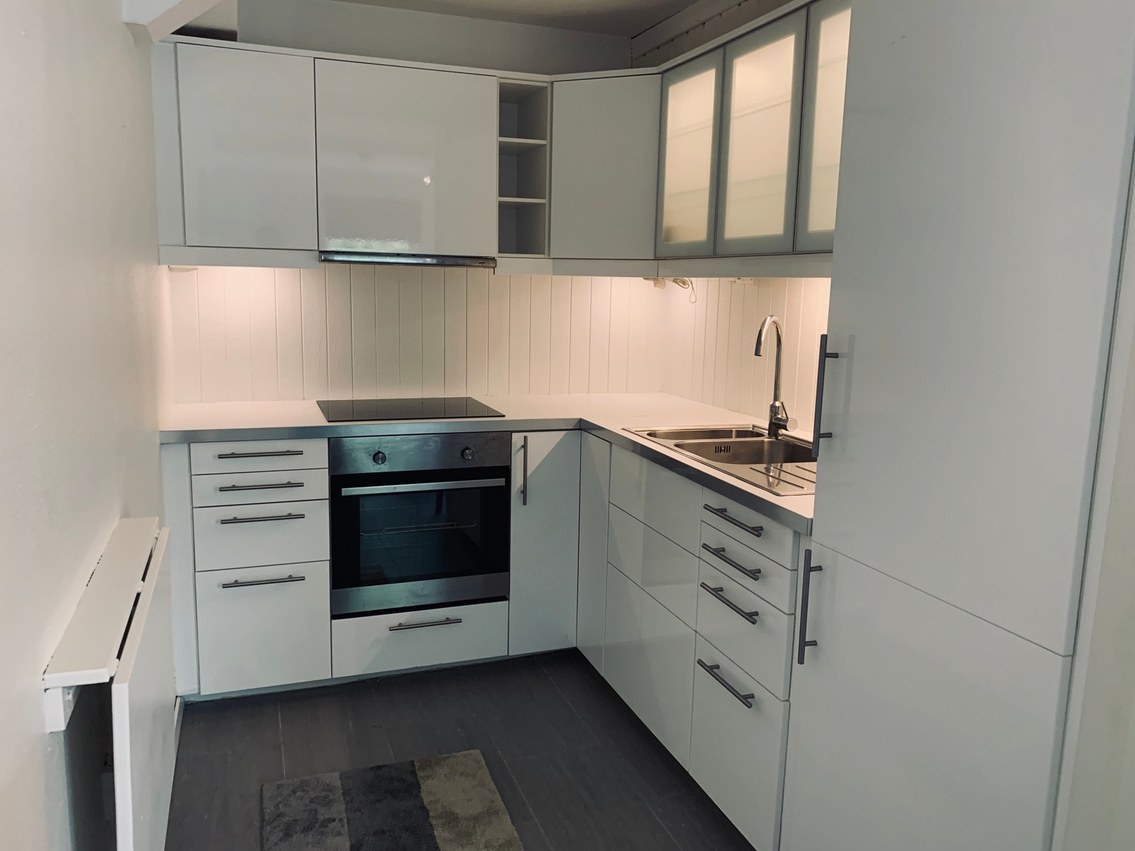 Kjøkken med komfyr, kjøleskap og frys, kjøkkenbord med barkrakk. Her er det god skapplass og benkeplass til å lage mat. Galleribilde