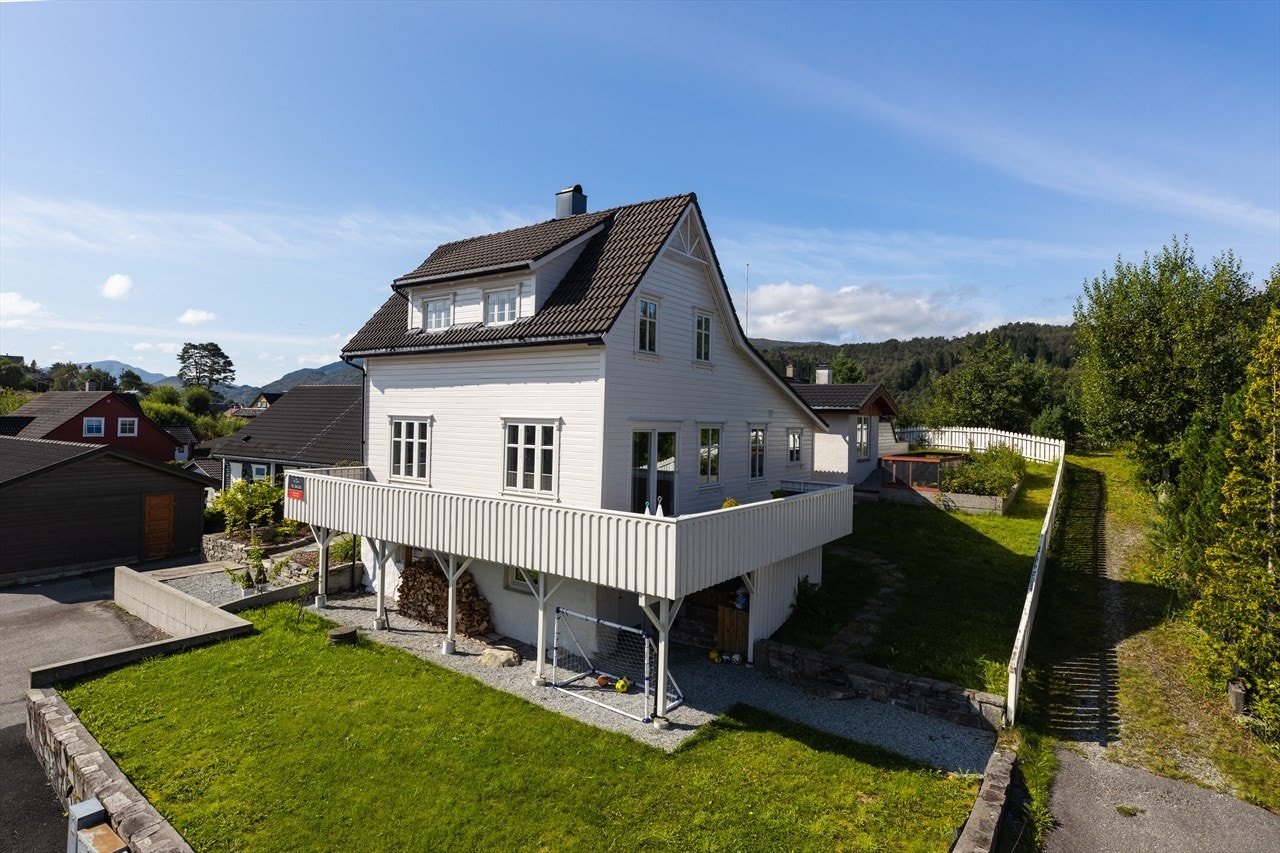 Boligen er omkranset av en pent opparbeidet tomt med plen, busker, åker og flere flotte utearealer. Galleribilde