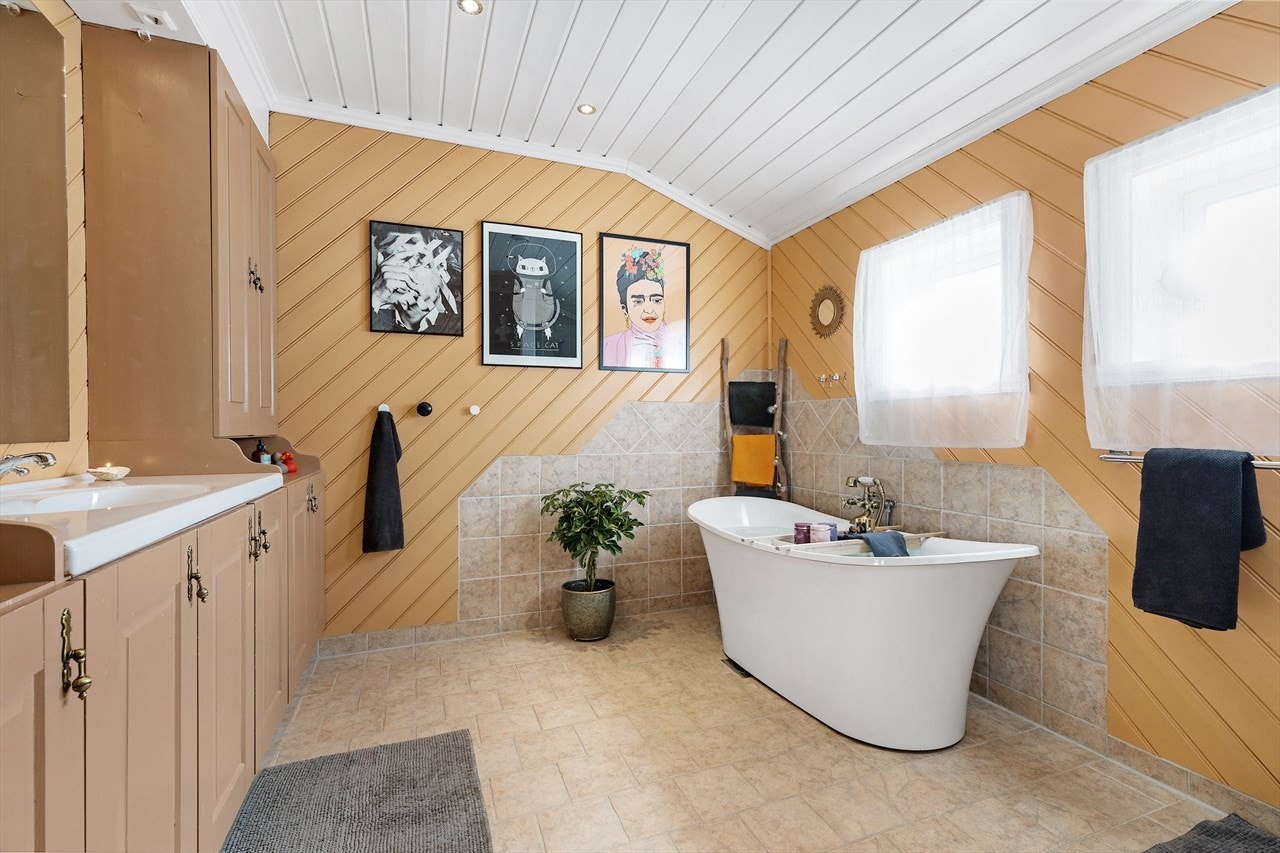 Meget romslig bad med fliser og varmekabler. Baderomsinnredning med mye lagringsplass. Galleribilde
