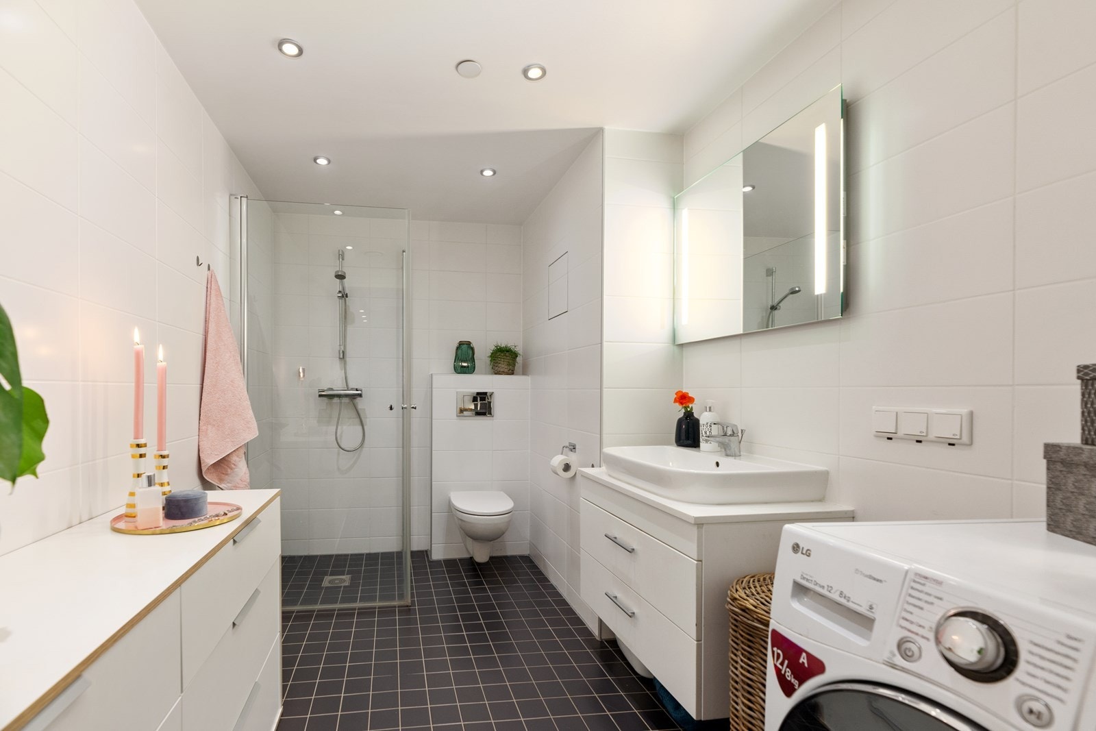 Badet er pent flislagt med vegghengt toalett, dusjnisje med innfellbare dusjvegger og downlights. Galleribilde