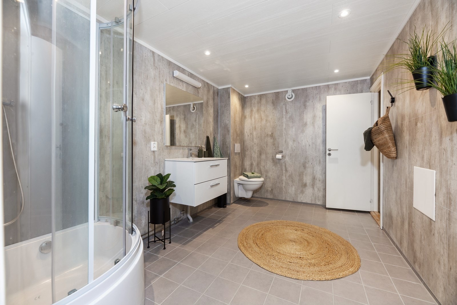 Badet er utstyrt med flis på gulv og våtromsplater på veggene. Ny og lekker baderomsinnredning, vegghengt toalett og dusjkabinett finnes av utstyr på badet. Galleribilde