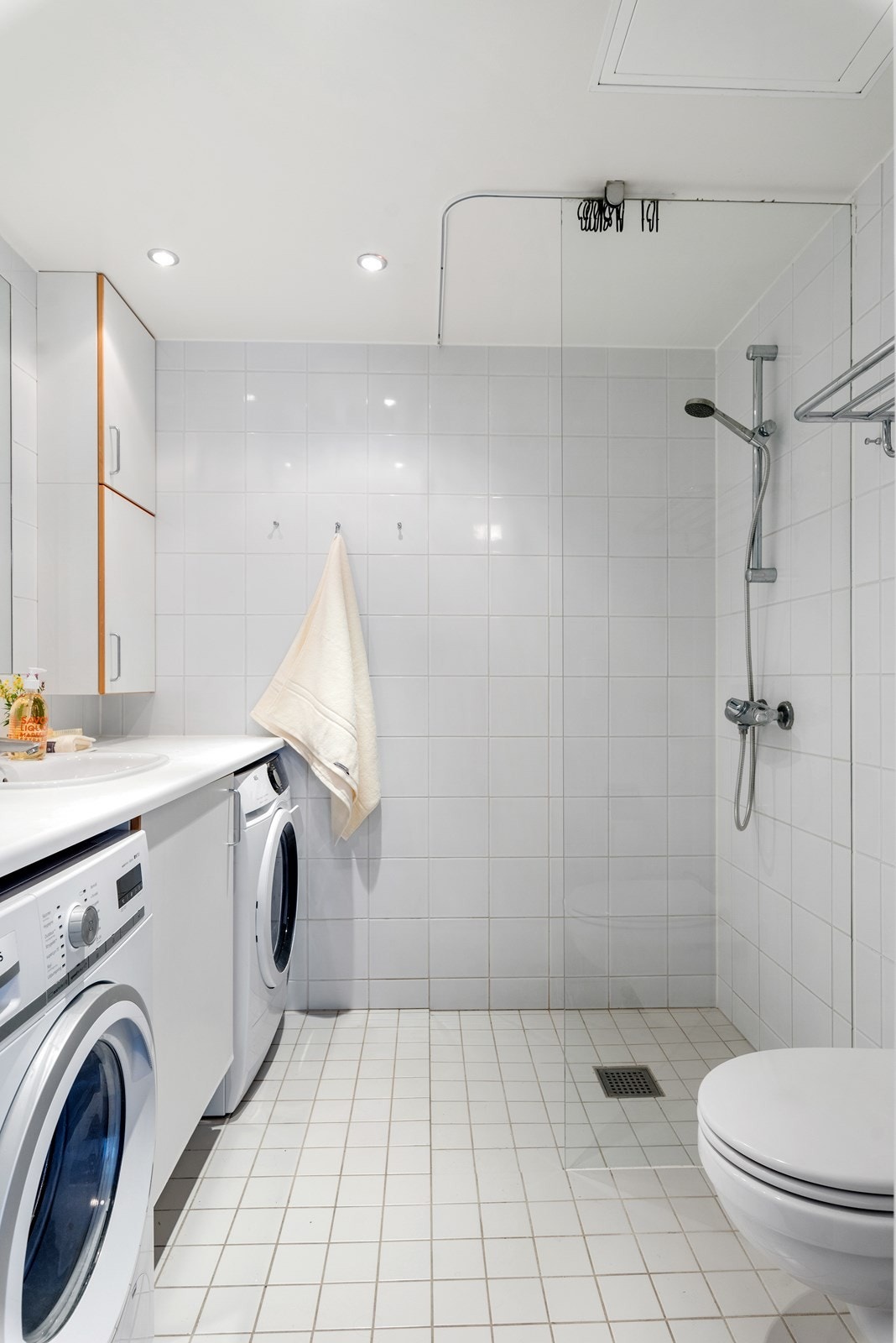 Hvite fliser - plass til vaskemaskin og tørketrommel. Galleribilde