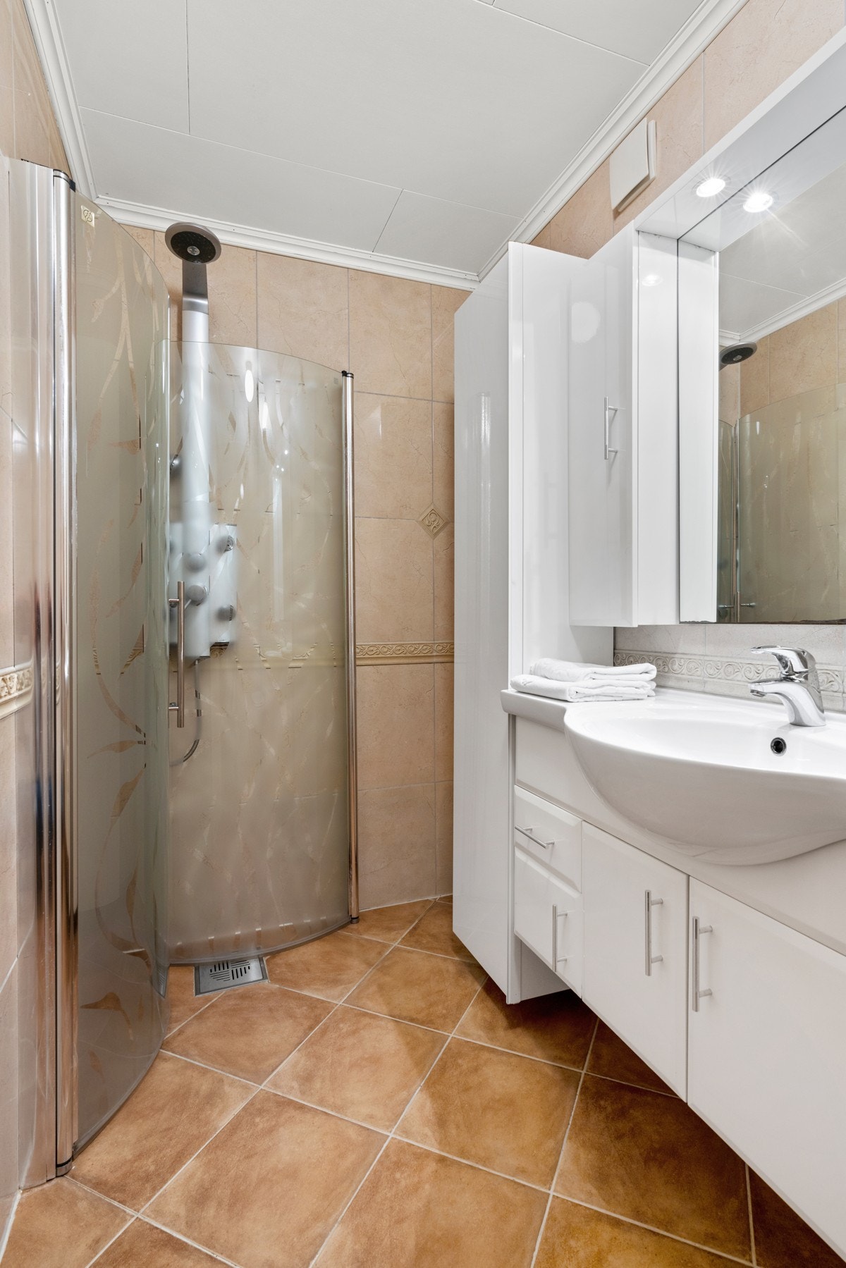 I hovedbadet er det tidsmessig innredning, varmekabler på gulv og dusjhjørne med innfellbare dører. Galleribilde