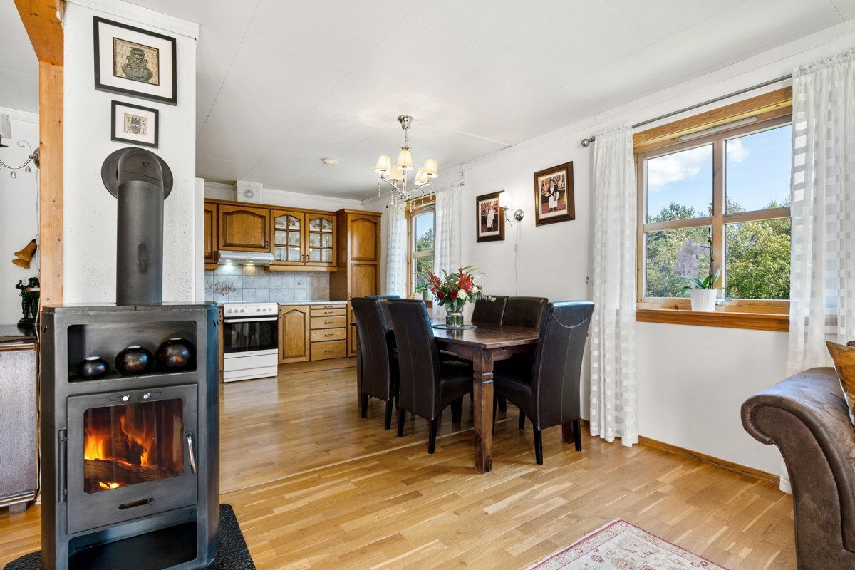 Sentralt i rommet er det en moderne peisovn som gir ekstra hygge. Galleribilde