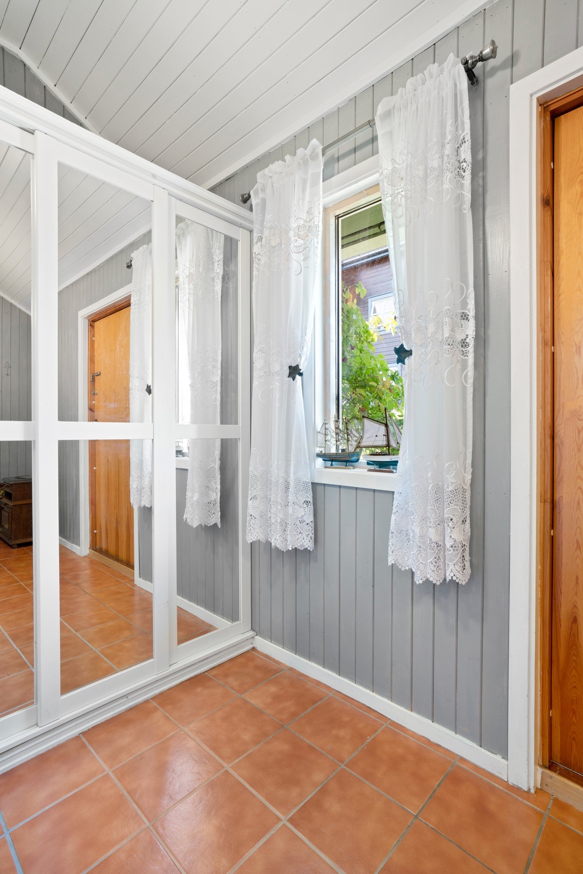 Hoveddelen har et hyggelig vindfang med gulvfliser og skyvedørsgarderobe. Galleribilde