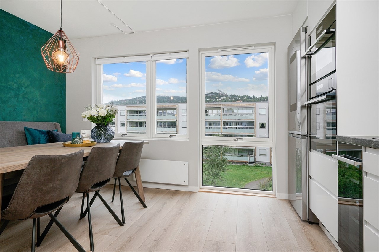 God plass til stort spisebord på kjøkken og fin utsikt mot Holmenkollen. Galleribilde