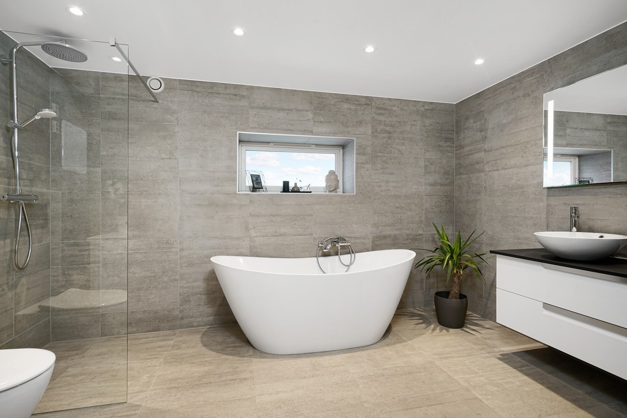 Baderom fra 2018. Flotte italienske fliser og varmekabler i gulv. Dusjhjørne med glassvegg og regndusj. Galleribilde