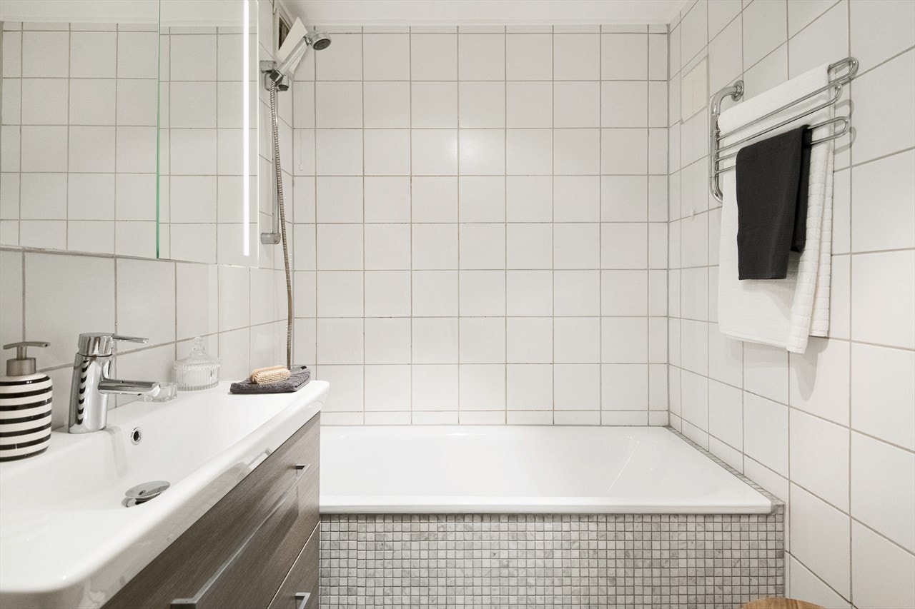 Flislagt bad fra 1995 med varmekabler og badekar. Galleribilde