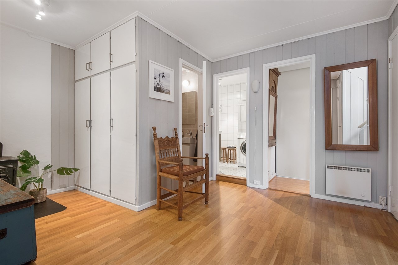 Inngangsparti med peisovn, garderobeskap og dører til separat toalett, bad og garderobe. Galleribilde