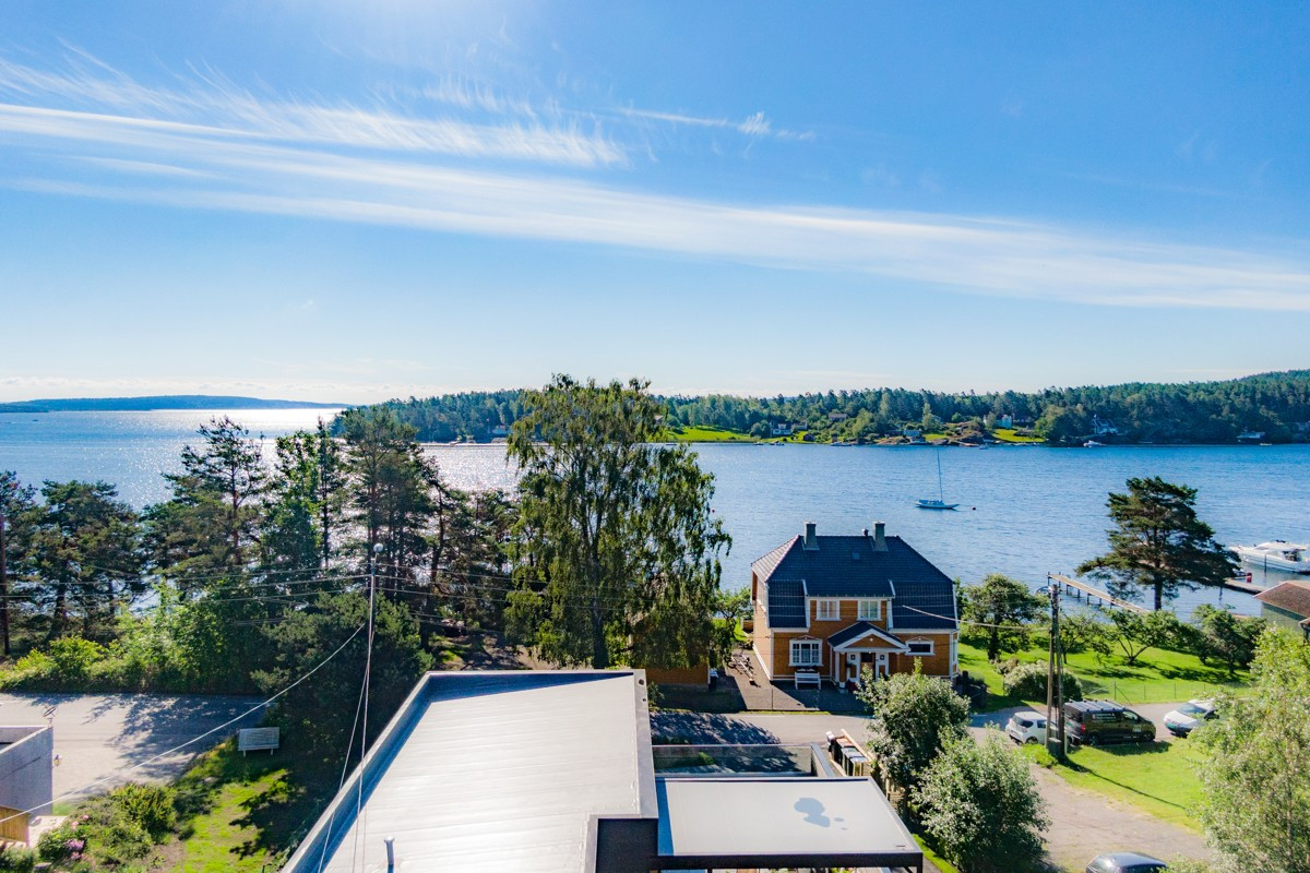Et steinkast fra sjøen ligger et nybygget, arkitekttegnet funkishus med lekre detaljer.