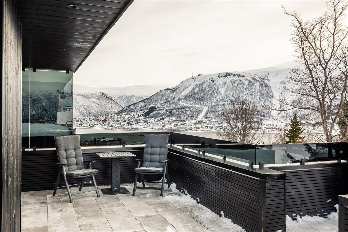 Stor terrasse med fliser og flott utsikt over til fastlandet