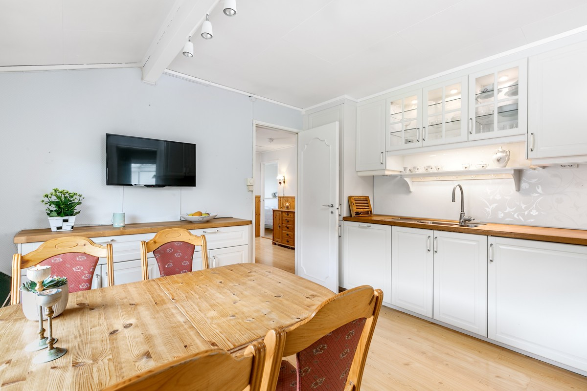 Kjøkken er nyoppusset, med tidsriktig hvite glatte fronter, integrerte hvitevarer og downlights over benk