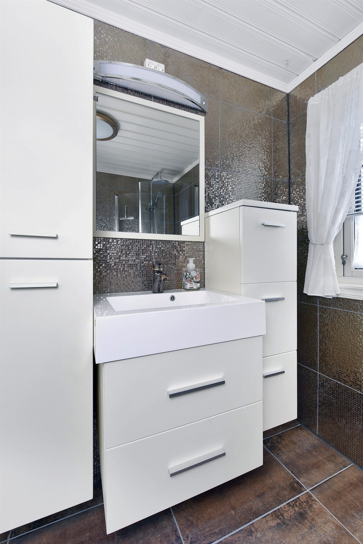 Innredningen består av en heldekkende servant med underskuffer og matchende veggskap. Galleribilde