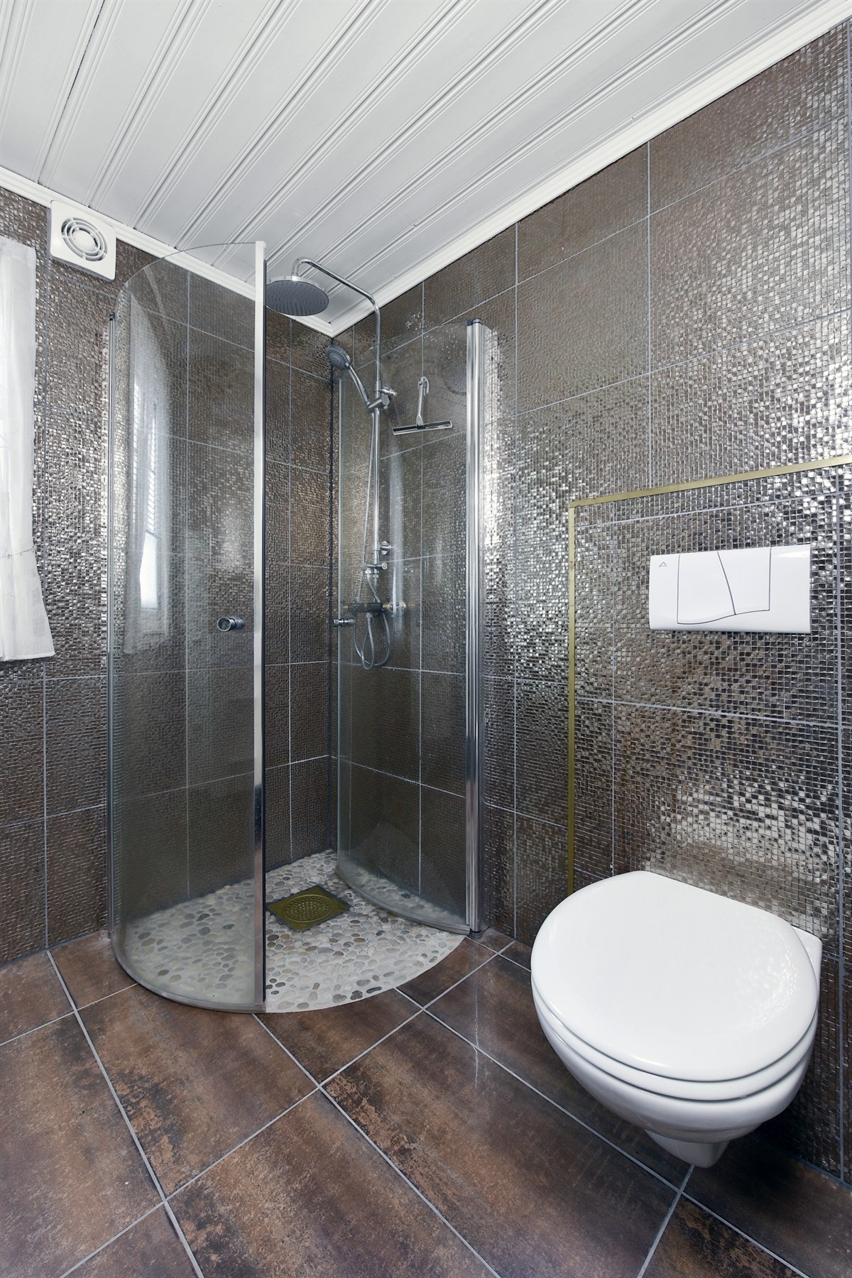 I tillegg har badet veggmontert toalett og et dusjhjørne med innfellbare glassdører. Galleribilde