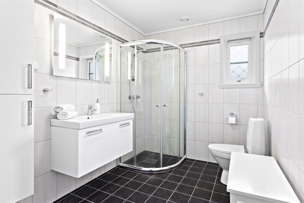 Pent bad i 1.etasje innredet med toalett, dusj og servant Galleribilde