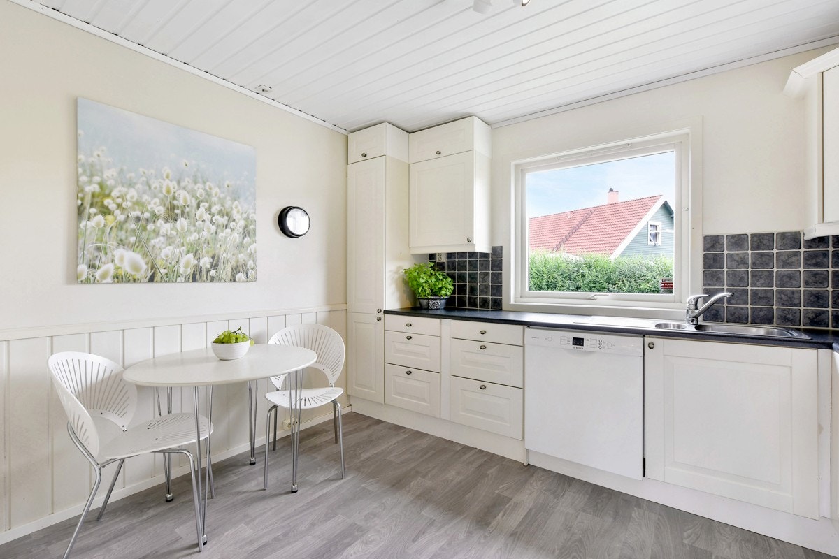 Det koselige kjøkkenet byr på god benke- og lagringsplass i L-formet samt har plass for et lite matbord. Galleribilde