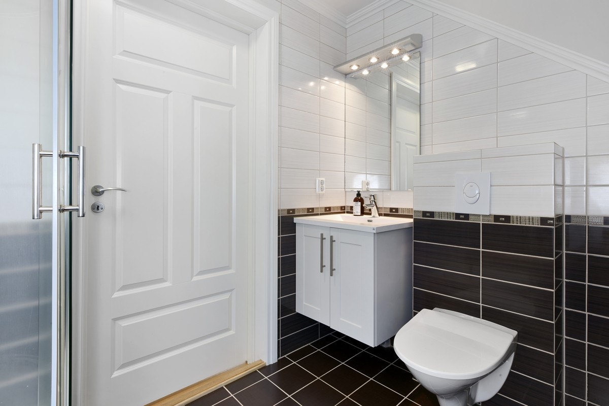 Badet er innredet med servant, vegghengt toalett og dusj. Galleribilde
