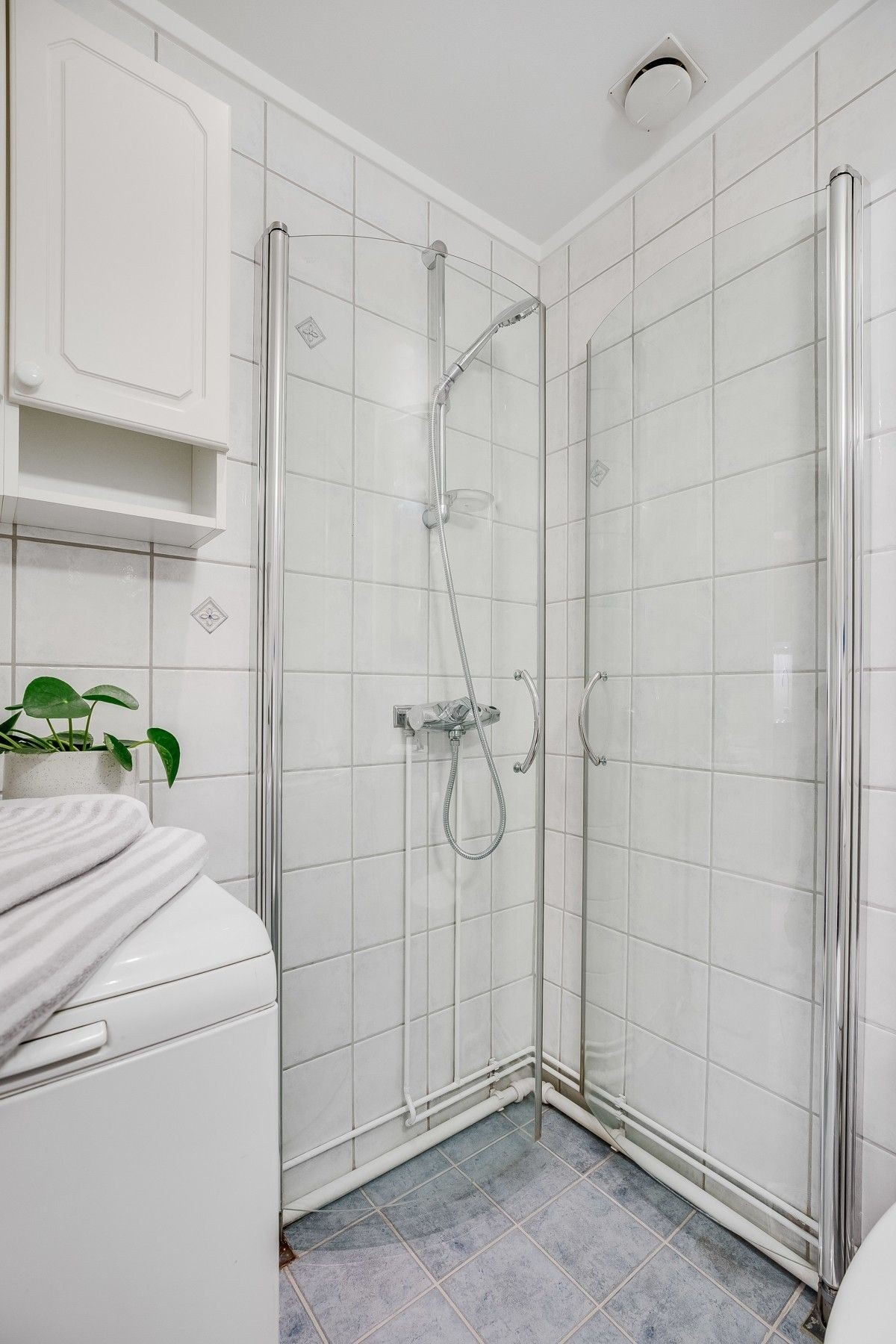 Badet er innredet med servant, dusjhjørne med foldbare glassdører samt opplegg for vaskemaskin Galleribilde