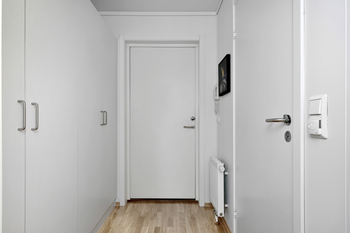 Leilighetens entré er lys og praktisk med parkett på gulv, to doble garderobeskap. Galleribilde