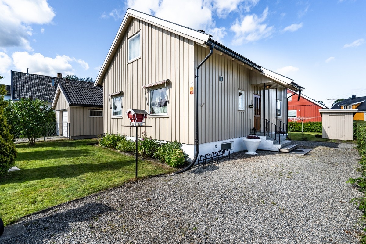 Tomten er pent opparbeidet med gressplen, hekk, blomster og noen trær. Galleribilde